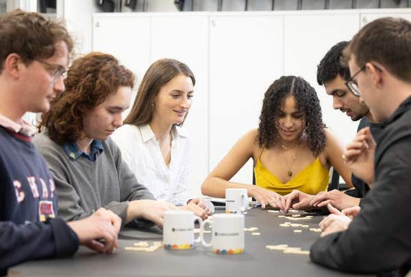 A group of students working together around a table during a training exercise