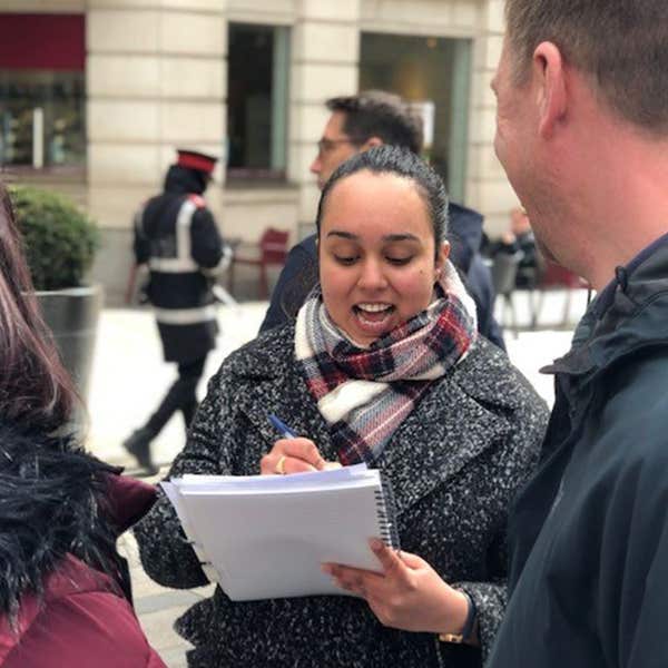 Trainee journalist interviewing a member of the public on a city street