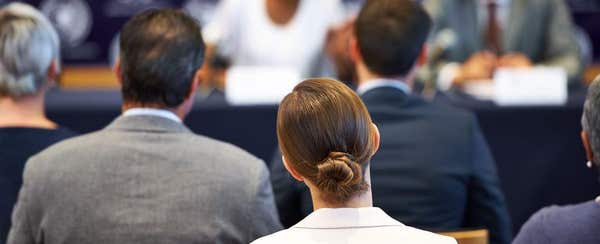 Delegates seated at tables during a key-messaging workshop, viewed from the back of the room