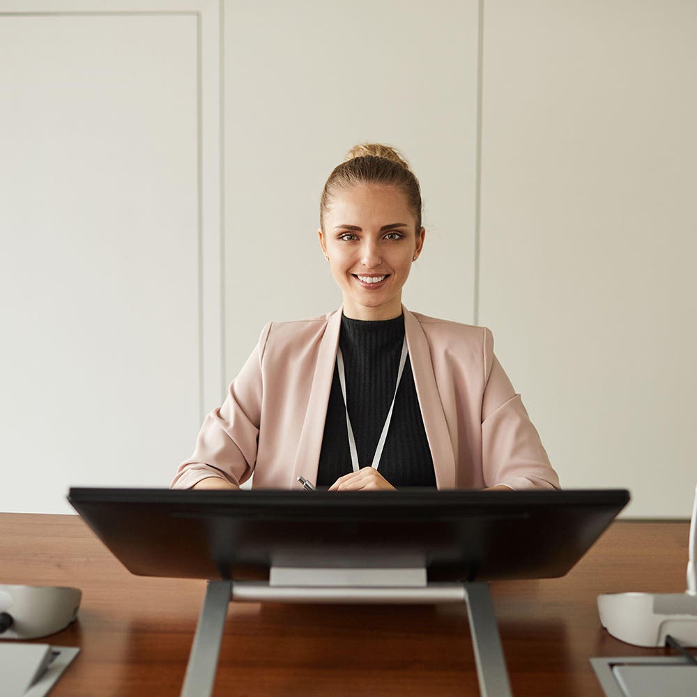 Speaker smiling behind a lectern in a conference room