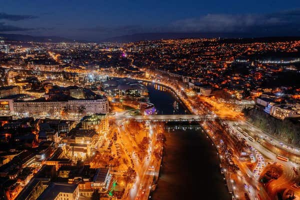 Panoramic night aerial view of Tbilisi, capital of Georgia from drone.