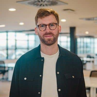 Portrait of a bearded journalist in glasses in an office