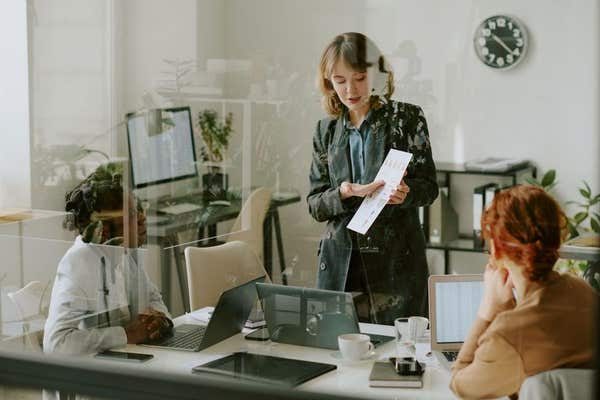 3BEP2NB Group of diverse professionals discussing marketing strategy in modern office space with glass walls and modern decor
