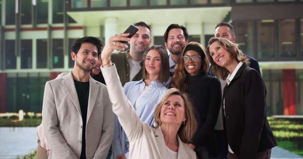 2SWNHDA Multiracial Business Team Smiling Together Taking Selfie at Work Event