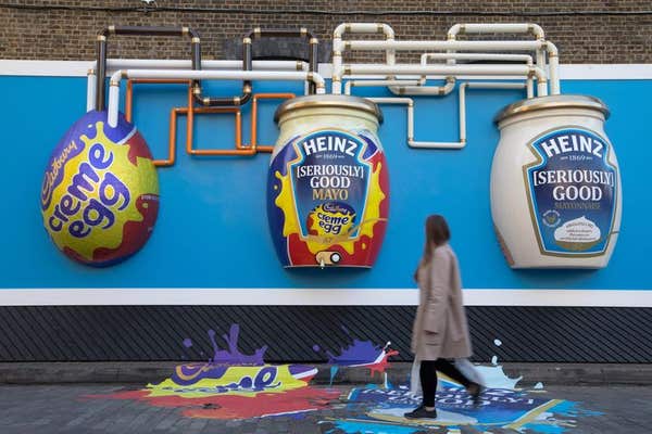EDITORIAL USE ONLY Passers-by look at the Heinz Creme Egg Mayo billboard, which is installed at the Old Truman Brewery in Lon