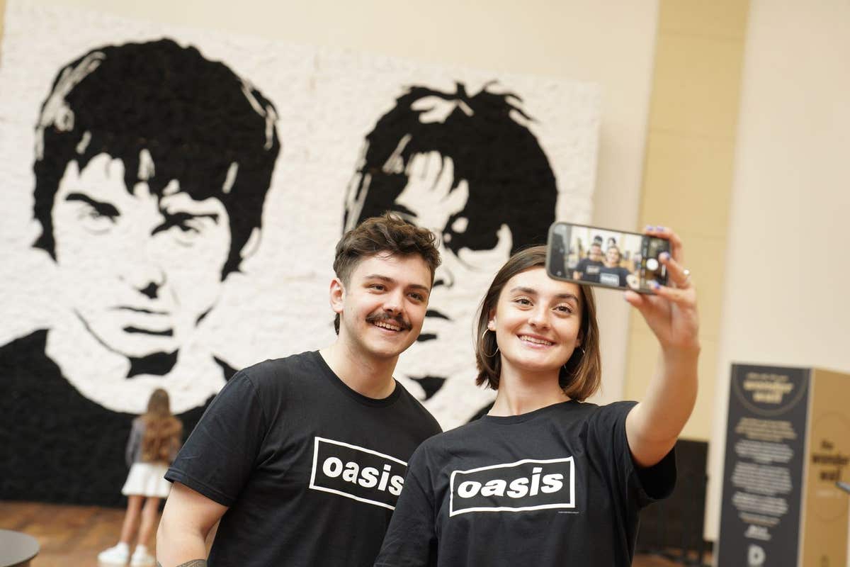 EDITORIAL USE ONLY Members of the public view ‘The Wonder Wall’, a monochrome portrait of Oasis bandmates Noel and Liam Galla
