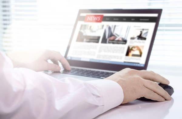 2B8CX9N Reader, journalist or writer with online news article on laptop screen. Digital media portal mockup. Latest daily pre