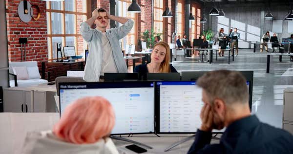 3E7K5KW Manager Struggles To Guide Team Through Stressful Office Crisis Meeting.