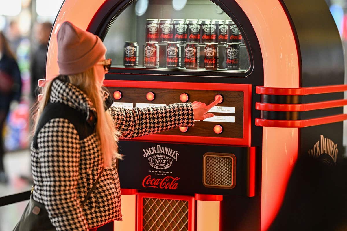 EDITORIAL USE ONLY Members of the public pick alternative festive songs using the Jack Daniel’s & Coca-Cola Jukebox, designed