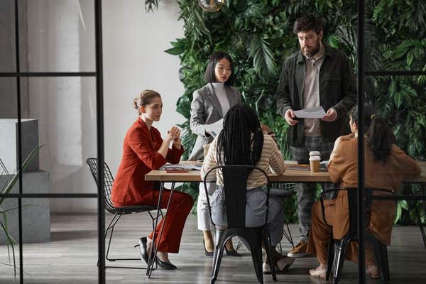 2F4PEEK Graphic full length portrait of diverse group of business people meeting at table in modern office interior, copy spa