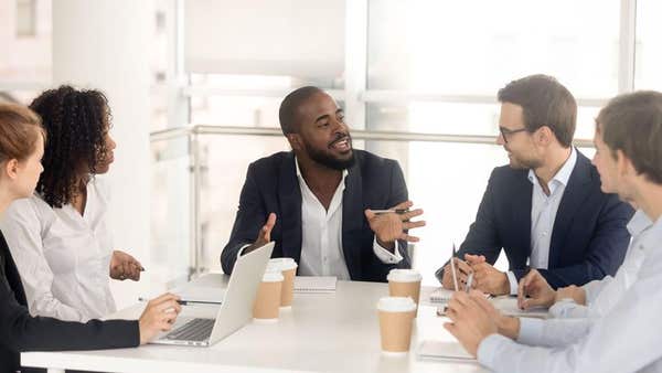 2B2730D Black male boss leading corporate in team meeting