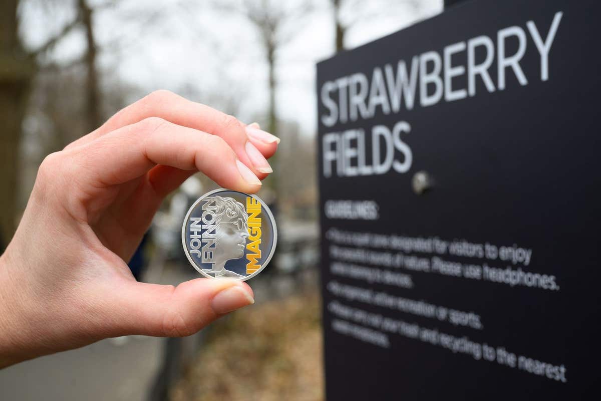 EDITORIAL USE ONLY A collectable coin featuring John Lennon and the word ‘Imagine’ is unveiled at the Strawberry Fields memor