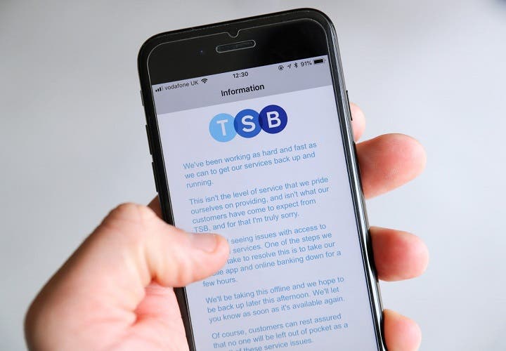 A customer using the TSB Online banking app on an iPhone reads a message from TSB CEO Paul Pester apologising for IT issues w