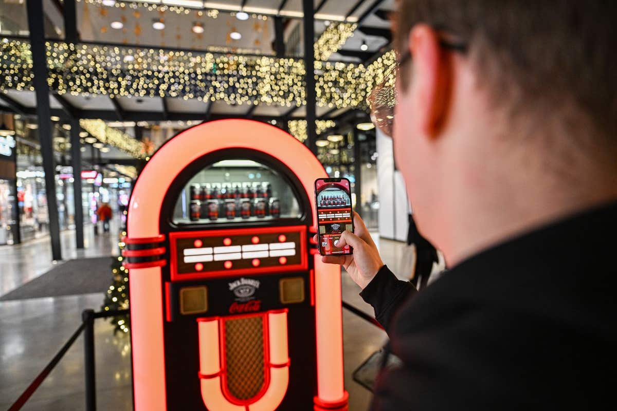 EDITORIAL USE ONLY Members of the public pick alternative festive songs using the Jack Daniel’s & Coca-Cola Jukebox, designed