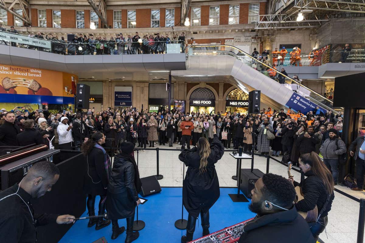EDITORIAL USE ONLY Gabrielle performs in front of commuters at London Waterloo Station along with Actimel who is looking to e
