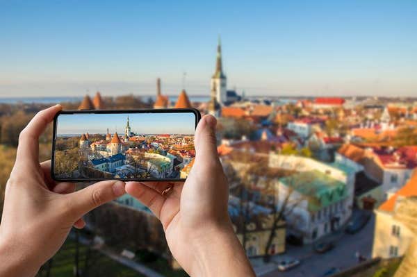 2CH2E9F Tourist taking photo of city center in Tallinn. Man holding phone and taking picture from above of Tallinn’s towers. 