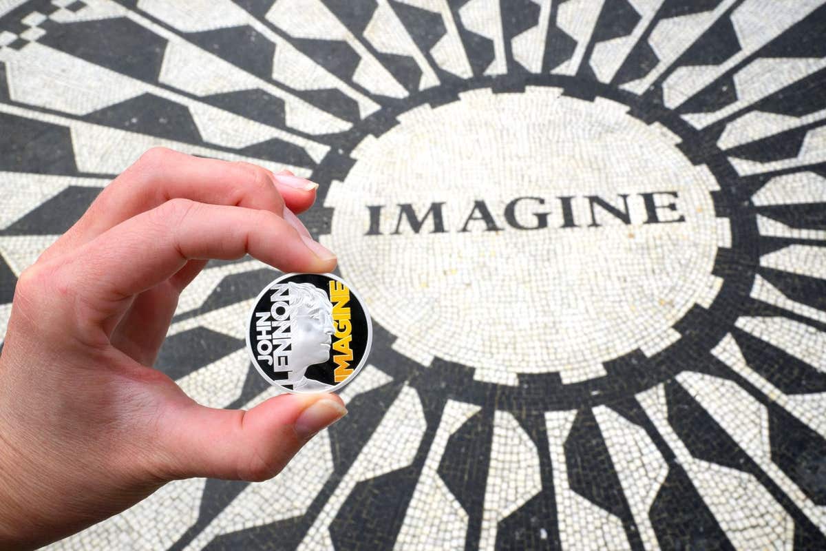 EDITORIAL USE ONLY A collectable coin featuring John Lennon and the word ‘Imagine’ is unveiled at the Strawberry Fields memor