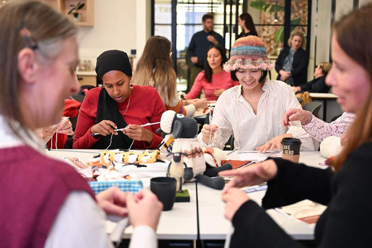 EDITORIAL USE ONLY Crafters Huda Warsame (left) and Wanling Xu (right) create a blanket from Shaun the Sheep-inspired knitted