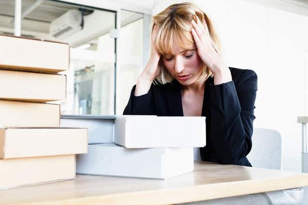 HEWP7D Business woman with stack of books, head in hands looking stressed