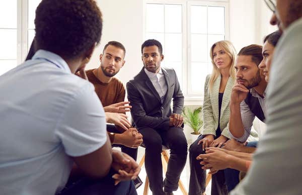 2J31YN2 Diverse group of serious business people discussing something during meeting in office