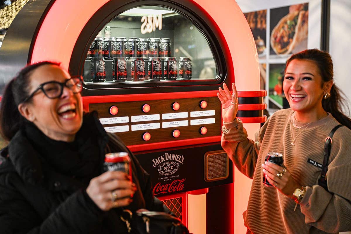 EDITORIAL USE ONLY Members of the public pick alternative festive songs using the Jack Daniel’s & Coca-Cola Jukebox, designed