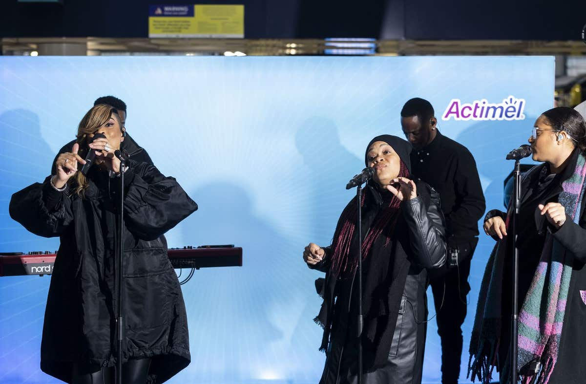 EDITORIAL USE ONLY Gabrielle performs in front of commuters at London Waterloo Station along with Actimel who is looking to e