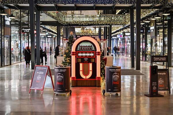 EDITORIAL USE ONLY Members of the public pick alternative festive songs using the Jack Daniel’s & Coca-Cola Jukebox, designed