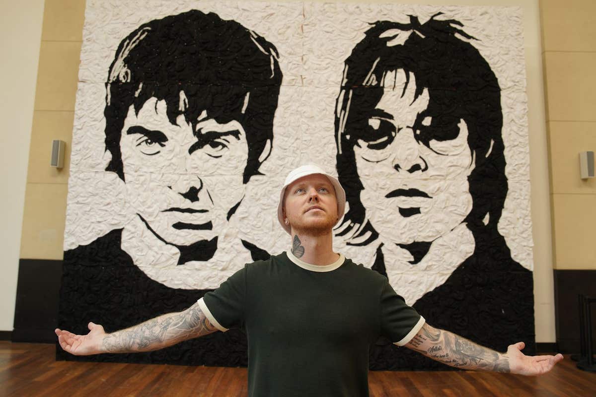 EDITORIAL USE ONLY Artist Nathan Wyburn with his artwork ‘The Wonder Wall’, a monochrome portrait of Oasis bandmates Noel and