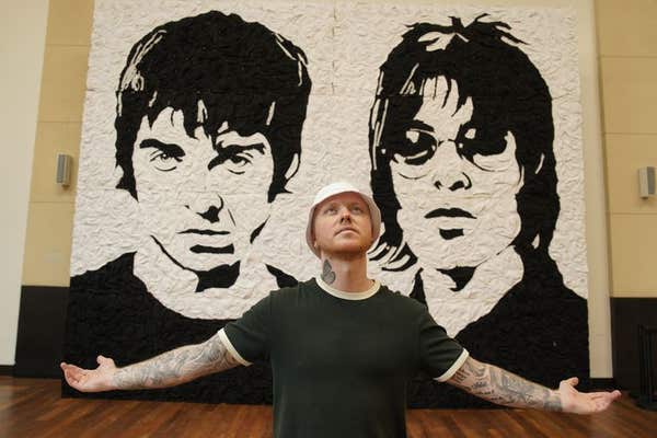 EDITORIAL USE ONLY Artist Nathan Wyburn with his artwork ‘The Wonder Wall’, a monochrome portrait of Oasis bandmates Noel and