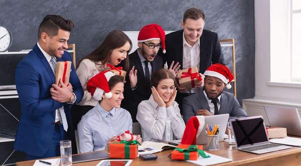 Group of young business people in Santa hats in office
